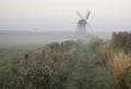 Old windmill in foggy countryside landscape in England Royalty Free Stock Photo