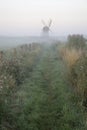 Old windmill in foggy countryside landscape in England Royalty Free Stock Photo