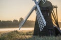 Old windmill in foggy countryside landscape in England