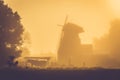 Old windmill at golden sunrise light, misty morning after rain Royalty Free Stock Photo