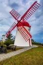 Old windmill Red Peak Mill in Bretanha (Sao Miguel, Azores). Traditional white wind mill with red roof and wings in village