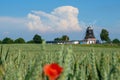 Old windmill stands behind a grain field in mecklenburg and the sky is blue