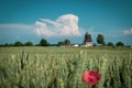 Old windmill stands behind a grain field in mecklenburg and the sky is blue Royalty Free Stock Photo