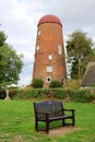 Old windmill tower and park bench Royalty Free Stock Photo