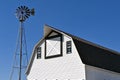 An old windmill and a white hip roofed barn Royalty Free Stock Photo