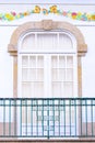 Old window with a balcony on a beautiful white house facade