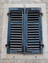 The old window with blue closed shutters on an old house. Vintage texture. Herceg Novi, Montenegro, old stone house Royalty Free Stock Photo