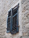 The old window with blue closed shutters on an old house. Vintage texture. Herceg Novi, Montenegro, old stone house Royalty Free Stock Photo