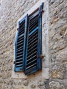 The old window with blue closed shutters on an old house. Vintage texture. Herceg Novi, Montenegro, old stone house Royalty Free Stock Photo