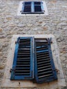 The old window with blue closed shutters on an old house. Vintage texture. Herceg Novi, Montenegro, old stone house Royalty Free Stock Photo