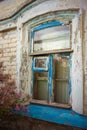 Old window with blue wooden frame with peeling paint. Rural house closeup Royalty Free Stock Photo