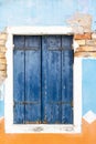 The old window with closed blue wooden shutter. Vertically. Royalty Free Stock Photo