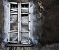 Old window with closed broken shutters