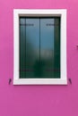 Old window with dark green shutters on pink (fucsia) wall Royalty Free Stock Photo