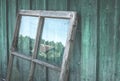 An old window frame stands against a plank wall in the countryside, reflecting a summer village landscape. Dismantling the old