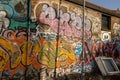 Old window frames leaning on the wall with colorful graffiti.