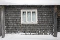 Old window and gray wooden wall covered with snow Royalty Free Stock Photo