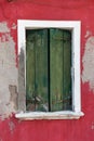 Old window with green shutters on red wall Royalty Free Stock Photo