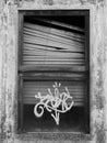 An old window that looks creepy and has a graffity on it on black and white. Royalty Free Stock Photo