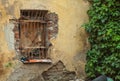 Old window with metal grid on an old peeling abandoned wall with