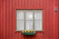 Old window of a red color wooden house, with flowerpot on facade. Stockholm, Sweden Royalty Free Stock Photo