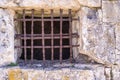 Old window with a rusty lattice on stone wall Royalty Free Stock Photo