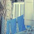 Old window with shutters and blue washing linen