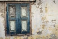 Old window with weathered closed wooden shutters and cracked wall Royalty Free Stock Photo