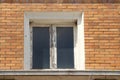 old window with wooden frame that needs a renovation on a brick house Royalty Free Stock Photo