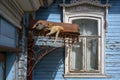 An old window with wooden platband and cats sleeping on an iron roof Royalty Free Stock Photo