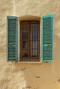 Old window with wooden shutters and rusty grille. Royalty Free Stock Photo