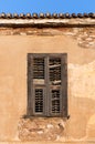 Old window with wooden shutters on a weathered wall, closeup background. Royalty Free Stock Photo
