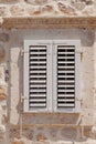 Old window with wooden shutters on yellow stucco wall and copy space Old Shutter windows with a flowers. Montenegro Royalty Free Stock Photo