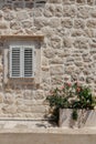 Old window with wooden shutters on yellow stucco wall and copy space Old Shutter windows with a flowers. Montenegro Royalty Free Stock Photo