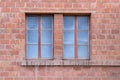 Two windows on a brick wall with blue glass panes Royalty Free Stock Photo