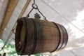 Old wine barrel with iron rings is suspended from a metal hook Royalty Free Stock Photo