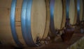 Old wine barrels in a wine cellar. Stacked up wine bottles in the cellar, dusty but tasty. Royalty Free Stock Photo