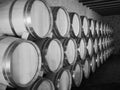 Old wine barrels in a wine cellar. Stacked up wine bottles in the cellar, dusty but tasty. Royalty Free Stock Photo