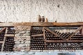 Old wine cellar with many dusty glass bottles and rustic wooden shelves on stone walls of rural storage of winery Royalty Free Stock Photo