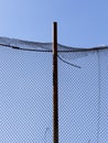 old wire fence made of thin wire against the blue sky