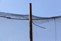 old wire fence made of thin wire against the blue sky