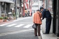 Old woman asks for direction from a police on the street of japan
