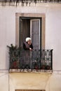 Old woman in a balcony of a facade of typical Lisbon house Royalty Free Stock Photo