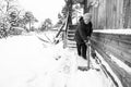 Old woman cleans the snow near her house in the russian village. Black and white photo. Royalty Free Stock Photo