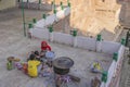A old woman cooking on firer beside the Tooji step well with a man and a boy in Jodhpur