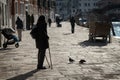 Old woman with crutches in a street in Venice