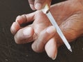 An old woman decorating nails with a nail file