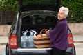 Old woman downloading the car Royalty Free Stock Photo