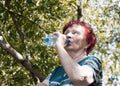 Old woman drinking mineral water Royalty Free Stock Photo