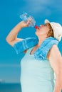 Old woman drinking mineral water in plastic bottle outdoor Royalty Free Stock Photo